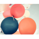 Bunch of balloons--orange, pink, blue--against blue sky wall print