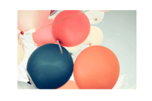 Bunch of balloons--orange, pink, blue--against blue sky wall print