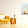 Yellow beach chair with white umbrella on beach wall print next to a yellow chair in living room