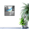 Giant blue bird standing in the middle of a street in black and white picture hanging on wall