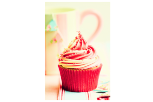 red, pink, and white cupcake with pink and white coffee mug in background