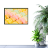 close up of macaroons in shades of yellow, pink, orange, and green print hanging on wall