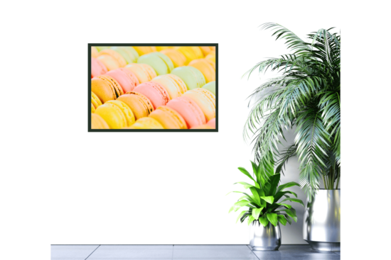 close up of macaroons in shades of yellow, pink, orange, and green print hanging on wall