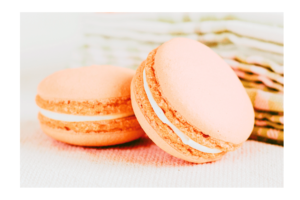 Two peach macaroons with green tea towel in background wall print