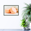 Two peach macaroons with green tea towel in background picture hanging on wall