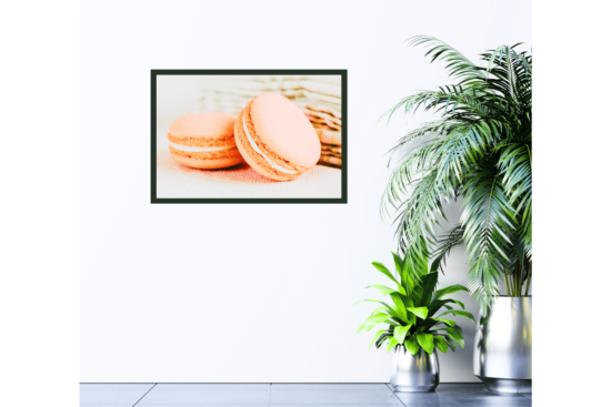 Two peach macaroons with green tea towel in background picture hanging on wall